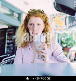 Schöne Frau, die einen Milchshake trinkt, Queensland, Australien. Stockfoto