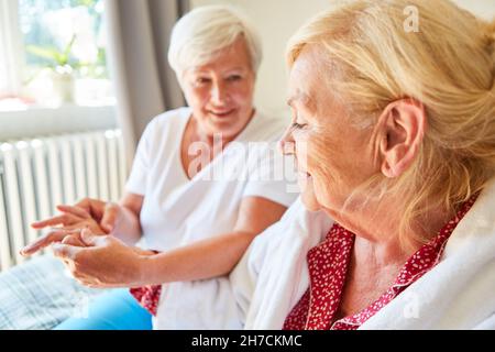 Physiotherapeutin massiert die Hand einer älteren Frau als Akupressur zu Hause oder im Pflegeheim Stockfoto