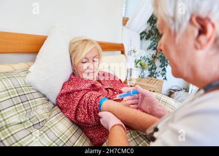Krankenschwester oder Pflegekraft verabreicht der kranken älteren Frau im Pflegeheim eine Injektion in den Unterarm Stockfoto