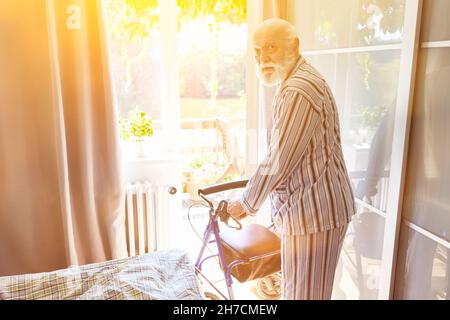 Alter Mann als Seniorpatient mit Gehhilfe nach Schlaganfall in der Reha-Klinik Stockfoto