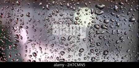 Bunte diffuse unscharfe Lichter hinter Glasfenster mit Regentropfen Stockfoto