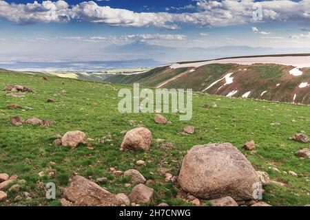 Panoramablick auf den Berg Ararat von den grasbewachsenen Hängen des Vulkans Aragats im frühen Frühjahr. Reiseziel und Wanderkonzept Stockfoto