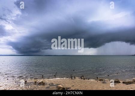 Approching Gewitter mit starken Niederschlägen über dem See, Deutschland, Bayern, Chiemsee, Chieming Stockfoto