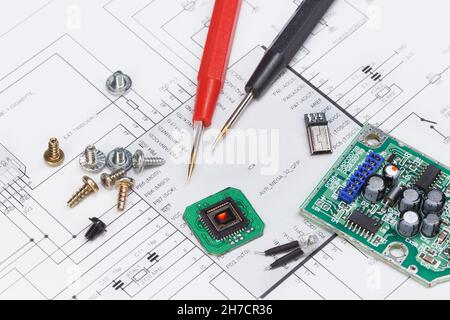 Diagramm eines elektronischen Geräts und darauf liegender elektronischer Module, Schrauben und Teile Stockfoto