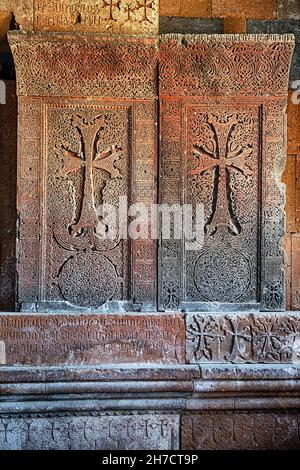 Traditionelle geschnitzte khachkar oder Kreuzstein aus rosa Tuff in der Nähe Hovhannavank Kloster installiert. Armenisches Erbe und Kunst Stockfoto