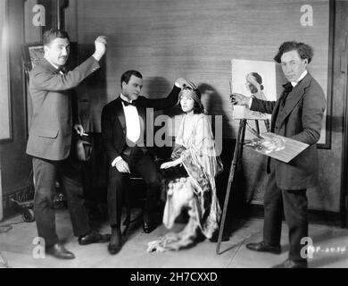 THOMAS MEIGHAN und GLORIA SWANSON am Set offen mit Artist Painting Portrait während der Dreharbeiten zu WARUM WECHSELN SIE IHRE FRAU ? 1920 Regisseur CECIL B. DeMille Geschichte William C. de Mille Kostümbild Clare West und (nicht im Preis enthalten) Natacha Rambova Famous Players - Lasky Corporation / Paramount Picles Stockfoto