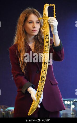 Ein Mitarbeiter von Bonhams zeigt das Lloyd's Patriotic Fund Trafalgar Sword, das Philip Durham, Kapitän der HMS Defiance bei der Schlacht von Trafalgar, verliehen wurde, eines der Gegenstände, die Bonhams am 24th. November in London zum Verkauf von Antique Arms and Armor anbieten wird. Bilddatum: Montag, 22. November 2021. Stockfoto