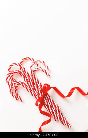 Weihnachten Candy Stöcke Haufen isoliert auf weißem Hintergrund. Bonbons in Pfefferminzrot, weiß, mit roter Schleife. Frohe Weihnachten Grußkarte Vorlage, Kopie sp Stockfoto