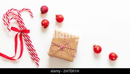 Weihnachtsgeschenk und Dekoration isoliert auf weißem Hintergrund. Geschenkbox und Bonbon Stöcke Haufen mit rotem Band Schleife, Draufsicht. Frohe Weihnachten Grußkarte Stockfoto