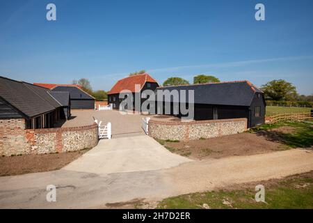 Great Sampford, Essex - April 16 2020: Ehemalige verödelte Bauernhöfe, die zu Häusern in abgelegener Landschaft mit Holz-Außenverkleidung umgebaut wurden Stockfoto