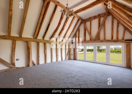 Great Sampford, Essex - April 16 2020: Home Innenschlafzimmer mit gewölbter Decke aus verderbter Farm Scheune umgewandelt, um schönen Wohnraum zu bieten Stockfoto