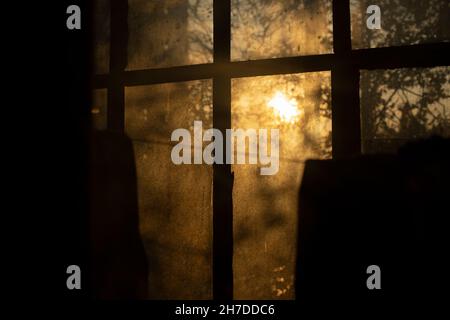 Die Sonne scheint am Morgen durch das Fenster. Warme Atmosphäre in der Luft. Gewöhnliches Fenster auf dem Balkon. Stockfoto
