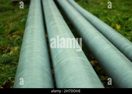 Heizleitungen in der Stadt. Heizrohre auf der Oberfläche. Details der städtischen Infrastruktur. Gasleitungen aus Edelstahl. Stockfoto