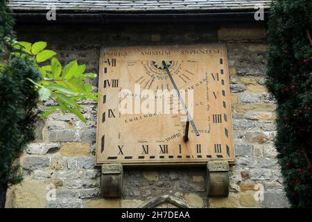 Sonnenuhr an der Wand der Kirche St. Lawrence, Church Street, Eyam (bekannt als das Pestdorf), Hope Valley, Peak District, Derbyshire, eng Stockfoto