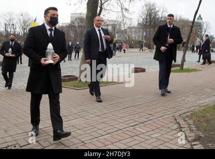 KIEW, UKRAINE - 21. NOVEMBER 2021 - der Präsident der Ukraine, Wolodymyr Zelenskyy (L), trägt eine Mahnlaterne zum Denkmal auf der Allee des Himmlischen Stockfoto