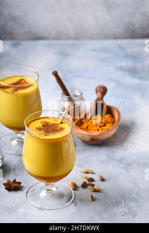 Kurkuma-Latte aus goldener Milch mit Zimtstangen und Honig. Gesundes ayurvedisches Getränk. Trendiges asiatisches natürliches Detox-Getränk mit Gewürzen für Veganer. Kopie en Stockfoto