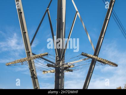 Anti-Kletterschutz auf Strommast mit Stacheldraht an klaren Tagen mit blauem Himmel. Stockfoto