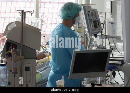 Leipzig, Deutschland. 08th. November 2021. Eine Krankenschwester betreut einen Patienten auf der Covid-Station, einem Bereich der operativen Intensivstation des Universitätsklinikums Leipzig. Auf der Intensivstation wächst seit Tagen die Zahl der Corona-Patienten mit schweren Verläufen, darunter immer mehr jüngere Patienten im Alter zwischen 30 und 60 Jahren. Quelle: Waltraud Grubitzsch/dpa-Zentralbild/dpa/Alamy Live News Stockfoto