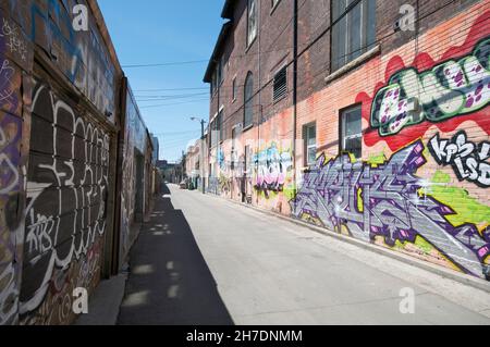Abstraktes buntes Fragment von Graffiti-Gemälden auf alten Ziegelwänden. Street Art Komposition mit Teilen von Unwri Stockfoto