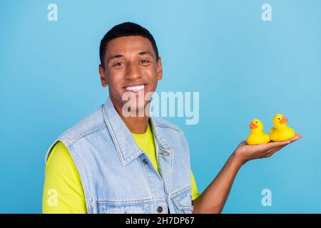 Profil Seite Foto von jungen fröhlich gute Laune afro Mann spielen Spielzeug isoliert über blauen Hintergrund Stockfoto