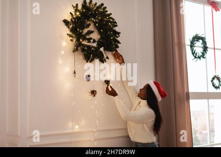 Porträt der glücklichen schwarzen Frau Dekoration Wohnung für Weihnachten Stockfoto