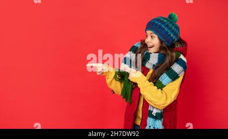 ausdruck positiver Emotionen. Wintermode. Zeigefinger auf Kopierraum. Stockfoto