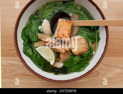 Udon Nudelsuppe mit Lachs und Spinat Stockfoto