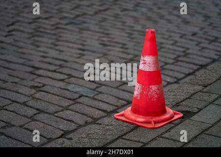 leuchtend orange Leitkegel stehen in einer Reihe auf dunklem asphalt Stockfoto