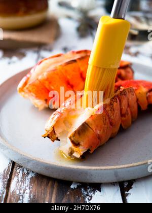 Schmelzende Butter auf gebratenen Hummerschwänzen Stockfoto