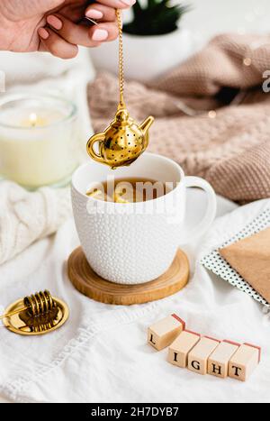 Tee mit einem goldenen Tee-Ei Stockfoto