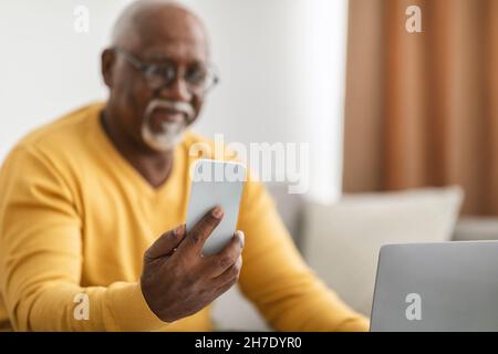 Älterer Schwarzer Mann, Der Ein Telefon Mit Einer Brille Im Freien Trägt Stockfoto