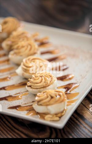 Deviled Eggs (gefüllte Eier) diagonal auf einem weißen Teller angeordnet Stockfoto