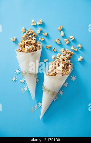 Weihnachts-Popcorn mit Ahornsirup, Zimt und Orangenschale in einem Papierkegel Stockfoto