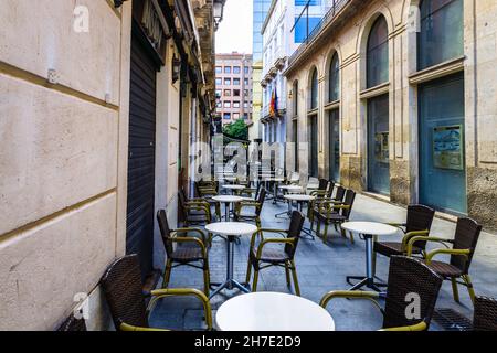 Stühle und Tische vor einer Terrasse mit Straßencafés Stockfoto