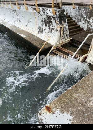 Vertikale Aufnahme einer alten Metalltreppe in das Meerwasser am Pier Stockfoto