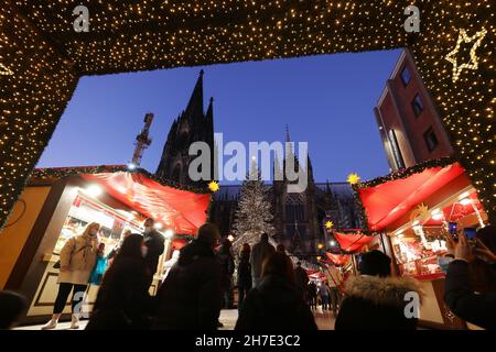Köln, Deutschland. 22nd. November 2021. Besucher spazieren durch den Weihnachtsmarkt am Roncalliplatz in der Nähe des Doms. Die Weihnachtsmärkte in Köln sind nach den Regeln von 2G für Besucher geöffnet. Quelle: Oliver Berg/dpa/Alamy Live News Stockfoto