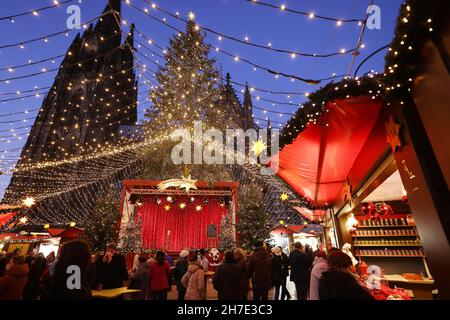 Köln, Deutschland. 22nd. November 2021. Besucher spazieren durch den Weihnachtsmarkt am Roncalliplatz in der Nähe des Doms. Die Weihnachtsmärkte in Köln sind nach den Regeln von 2G für Besucher geöffnet. Quelle: Oliver Berg/dpa/Alamy Live News Stockfoto