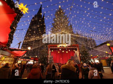 Köln, Deutschland. 22nd. November 2021. Besucher spazieren durch den Weihnachtsmarkt am Roncalliplatz in der Nähe des Doms. Die Weihnachtsmärkte in Köln sind nach den Regeln von 2G für Besucher geöffnet. Quelle: Oliver Berg/dpa/Alamy Live News Stockfoto