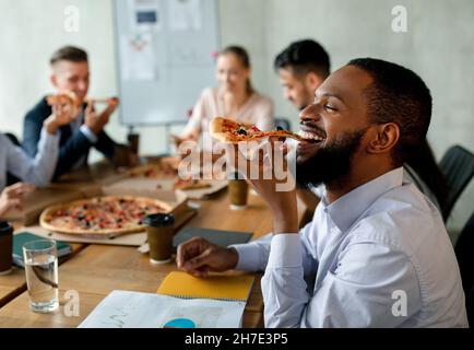 Mittagspause Für Unternehmen. Eine Gruppe Von Kollegen, Die Im Büro Takeaway Pizza Essen Stockfoto