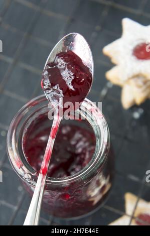 Johannisbeermarmelade in einem Glas mit einem Löffel zum Füllen von Marmeladengebäck Stockfoto