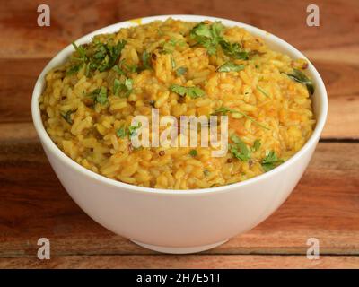 Dal khichdi oder Khichadi, leckere indische Rezept serviert in Schüssel über rustikalen Holzhintergrund, das Essen aus Dal und Reis mit ganzen Gewürzen kombiniert, o Stockfoto