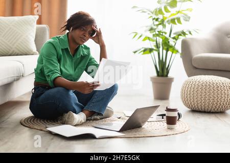 Unglückliche Afrikanische Weibliche Holding-Papiere Lesen Negative Nachrichten Indoor Stockfoto