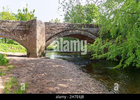 Die rote Sandsteinbrücke begann 1753 über den Fluss Irthing in Ruleholme, Cumbria, Großbritannien Stockfoto