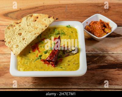 Dal khichdi oder Khichadi, leckere indische Rezept serviert in Schüssel über rustikalen Holzhintergrund, das Essen aus Dal und Reis mit ganzen Gewürzen kombiniert, o Stockfoto