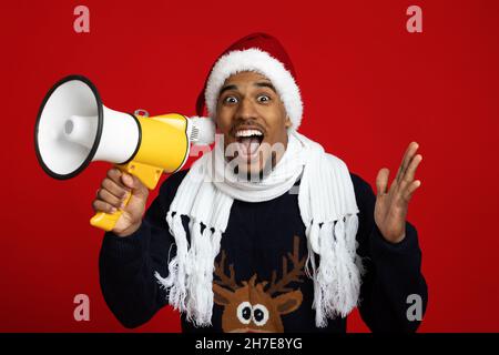 Afroamerikanischer Mann in Santa hat mit Lautsprecher Stockfoto