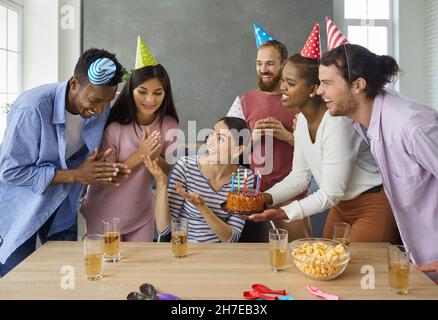 Gruppe von fröhlichen jungen Menschen gratulierenden Freund zum Geburtstag zu Hause Stockfoto