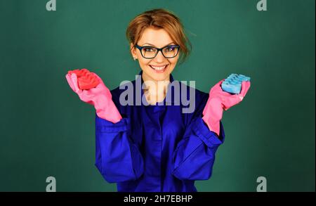 Glückliche Frau in Uniform und Gummihandschuhe mit Schwamm zum Waschen. Werbung für Reinigungsservice Stockfoto