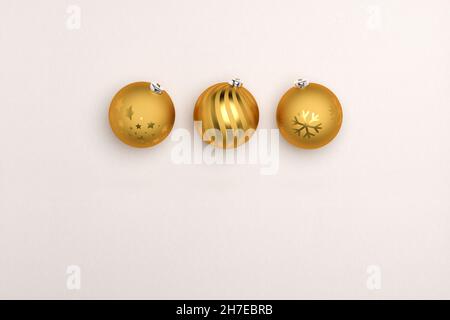 Drei goldene weihnachtskugeln auf Papierhintergrund. Kopieren Sie den Platz unten für Ihre eigene Nachricht. Stockfoto