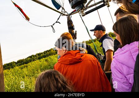 Vilnius, Litauen - 14. September 2021: Passagiere im Korb beobachten den Landevorgang des Heißluftballons Stockfoto