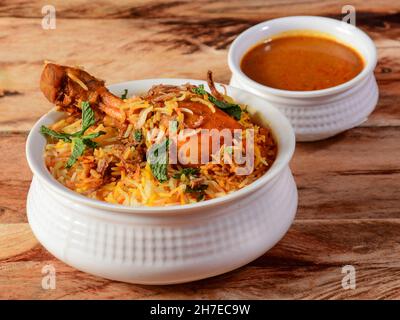 Traditionelles Hyderabadi Chicken dum Biryani aus Basmati-Reis, zubereitet mit Masala-Gewürzen, serviert mit Salan, selektiver Fokus Stockfoto